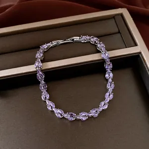 Detail shot of a silver-tone bracelet with marquise-cut purple zircons on a display box.