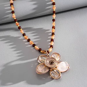 Dettaglio macro di una collana vintage di perline di cristallo con ciondolo a fiore