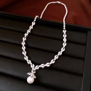 Detailed view of elegant leaf-shaped zircon necklace with round pearl pendant drop