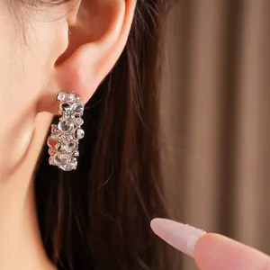 Eleganti orecchini a cerchio a C in argento con zirconi e bolle di resina trasparente.