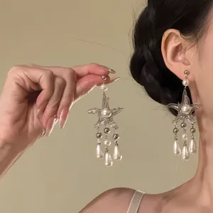 Elegant silver starfish tassel earrings with pearls for a vacation look.