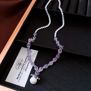 Detailed view of luxury zircon necklace with purple stones and a white pearl pendant