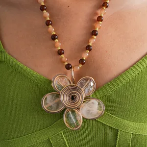 Primo piano di una collana vintage di perle di cristallo con un grande ciondolo a fiore.