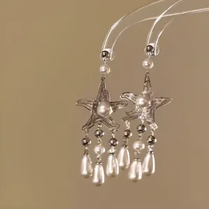 Detailed view of silver starfish tassel earrings with elegant white pearls for beach vacations