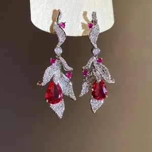 Detail view of elegant S925 silver needle leaf earrings with red teardrop zircon stones.