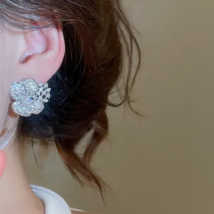 Macro detail of elegant sparkling zircon flower stud earrings showing fine craftsmanship.