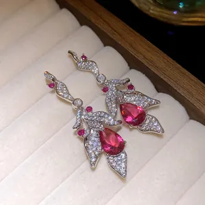 Detailed macro view of elegant silver drop earrings with pink zircon and leaf pattern
