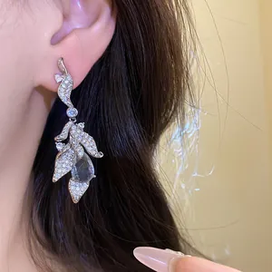 Close-up of elegant zircon leaf pendant earring with waterdrop stone on an Asian model