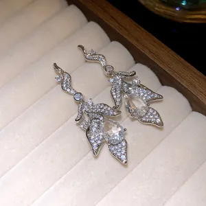 Detailed view of silver-plated leaf earrings featuring sparkling teardrop zircon pendants