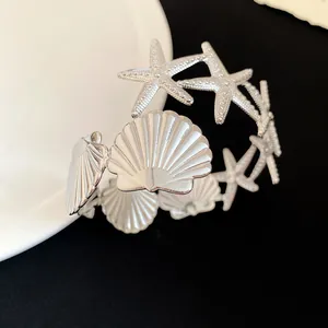Close-up detail of silver starfish and seashell metal armlet bracelet jewelry design