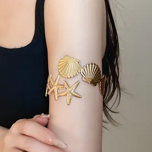 Gold-tone starfish and shell arm cuff bracelet for elegant summer beach fashion style.