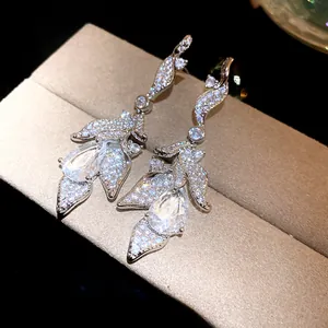 Detailed close-up of silver earrings featuring sparkling zirconia leaf and teardrop design