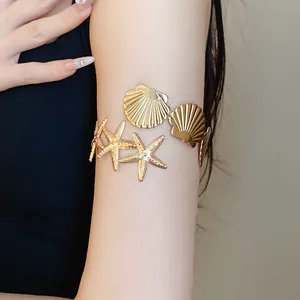 Close-up detail shot of gold metal starfish and shell decorative arm cuff bracelet