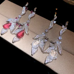 Close-up of silver leaf drop earrings with sparkling pink and clear pear zircons