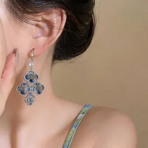 Close-up view of elegant French vintage zircon flower tassel dangle earrings worn by model.