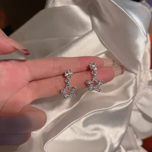 Detailed macro view of silver-tone star stud earrings with sparkling cubic zirconia stones