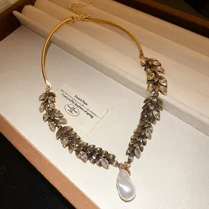Gros plan d'un collier vintage en épi de blé avec un pendentif en perle baroque