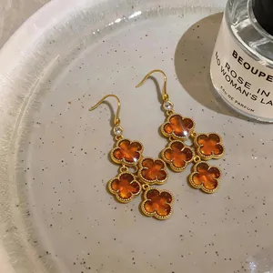 Macro detail of amber flower pendants and gold plated hooks with zircon accents