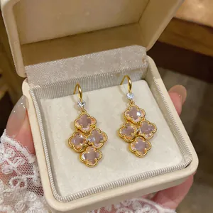 Close-up of French vintage zircon clover drop earrings in a luxury jewelry box.
