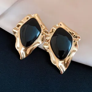 Detail of vintage irregular geometric stud earrings with black enamel and gold finish
