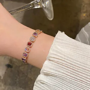 Close-up view of a French vintage gold bracelet with colorful square zircon gemstones