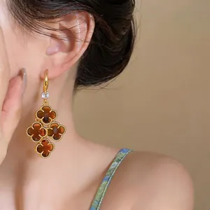 Close-up of French retro gold tassel earrings with brown flower charms
