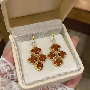 Detailed view of French vintage zircon flower tassel earrings in a cream jewelry box.