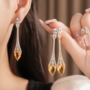 Dettaglio degli orecchini pendenti in zircone placcato oro 18k con pietre ambrate