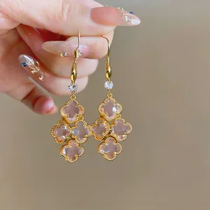 Close-up of French vintage drop earrings with pink four-leaf clover motifs and zircons.