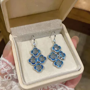 Detailed view of vintage blue four-leaf clover zircon drop earrings in a luxury box