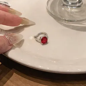 Dettaglio di un clip per orecchio vintage non forato con pietra rossa quadrata