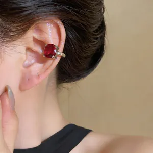 Dettaglio di un ear cuff con zircone rosso in stile vintage per orecchi non forati