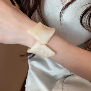 Vista detallada del brazalete de resina crema con diseño geométrico retorcido
