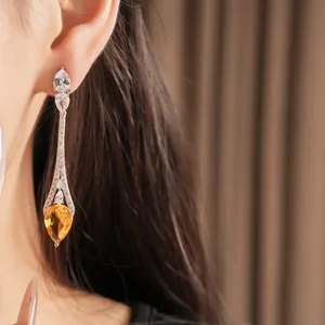 Primo piano di eleganti orecchini a goccia placcati in oro 18k con zircone giallo