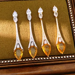 Dettaglio ravvicinato di orecchini a goccia placcati oro 18k con pietre gialle brillanti