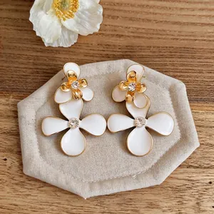 Elegantes pendientes de flores en esmalte blanco de estilo corte francesa con cristales