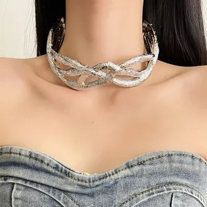Detailed close-up of a chunky silver textured metal choker necklace with a twisted knot design