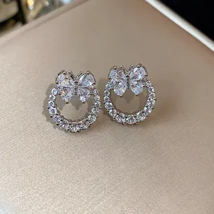 Dettaglio di eleganti orecchini a farfalla in argento con pietre di zircone scintillanti.