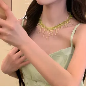 Détail d'un collier de perles fleuri fait main porté comme un tour de cou style Mori