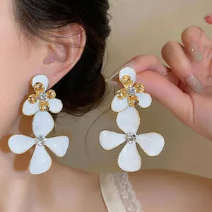 Pendientes colgantes de flores blancas estilo francés con detalles dorados y cristales
