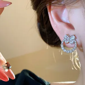 Primo piano di eleganti orecchini a farfalla in zirconia sull'orecchio della modella.