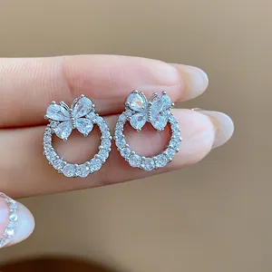Dettaglio macro di eleganti orecchini a farfalla in argento con zirconi luminosi.