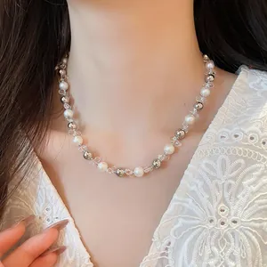 Detail view of a French style necklace with white pearls, silver beads and clear spacers