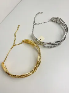 Detailed view of metallic crushed pleated twisted necklaces in gold and silver finishes