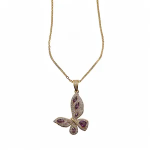 Elegant gold butterfly pendant necklace with purple and white zircons on white background