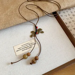 Detail of a vintage ethnic style necklace featuring bronze leaf charms and rustic beads