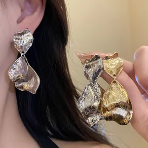 Close-up of vintage metallic wrinkled petal earrings in gold and silver finishes
