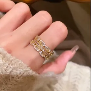 Dettaglio ravvicinato di anello vintage dorato con zirconi lucenti e design a pizzo