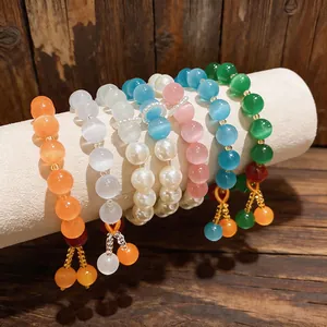Braccialetti di perline occhio di gatto colorati con eleganti nappe su supporto bianco