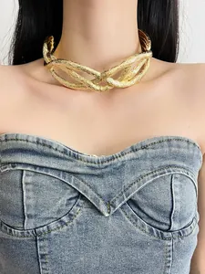 Close-up of a textured gold twisted metal choker necklace on a model's neck